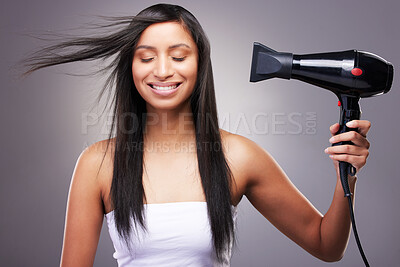 Buy stock photo Cosmetics, woman and hairdryer with smile in studio grey background for model and self care. Female person, heat treatment and happy isolated against backdrop for salon shine, style and keratin