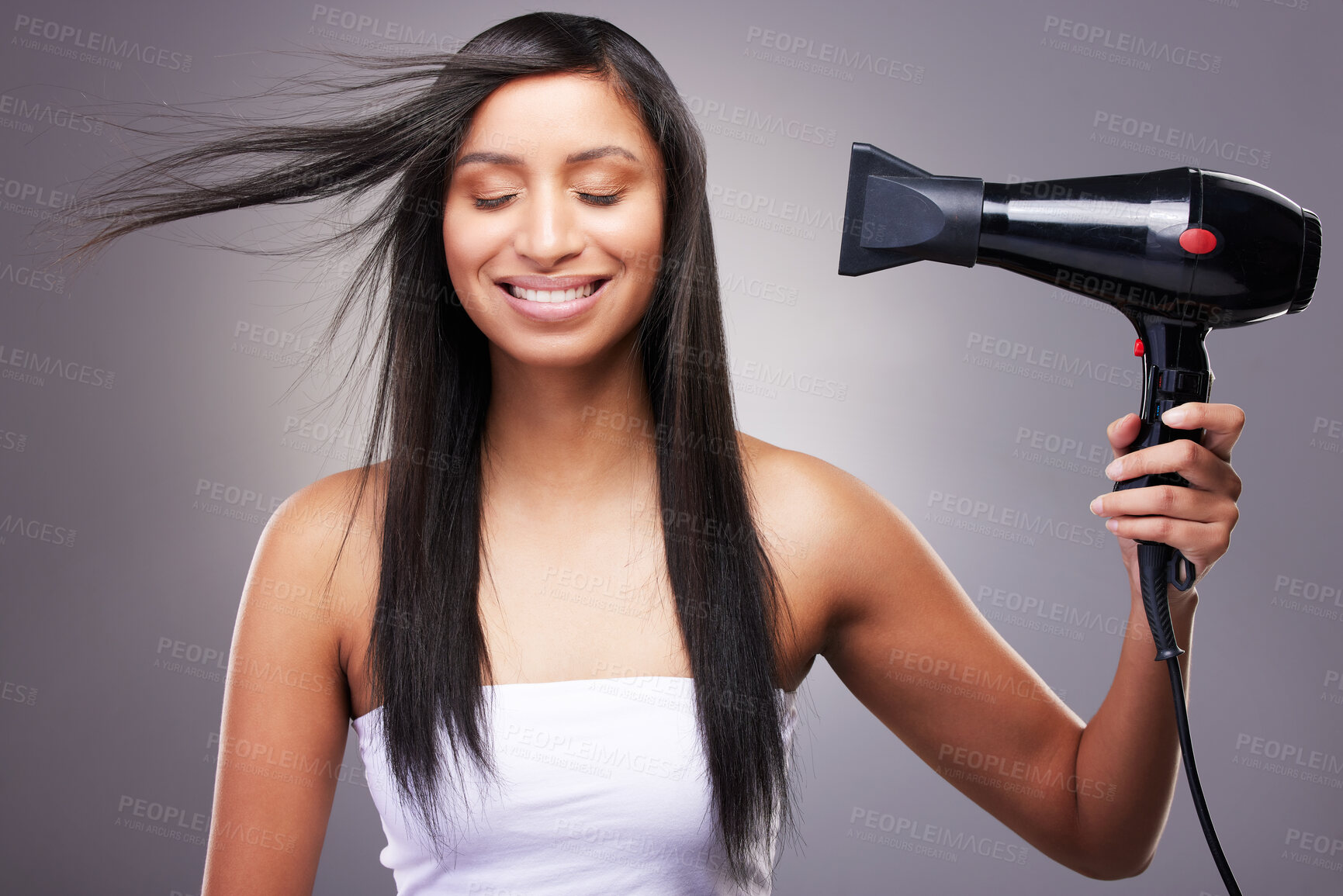 Buy stock photo Cosmetics, woman and hairdryer with smile in studio grey background for model and self care. Female person, heat treatment and happy isolated against backdrop for salon shine, style and keratin