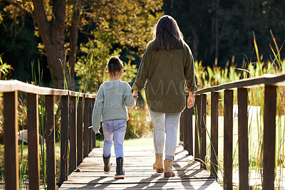 Buy stock photo Back, mother and girl holding hands, park and bonding with love, family and carefree with sunshine. Parent, mama and daughter outdoor, walking and break with care, natural and quality time outside