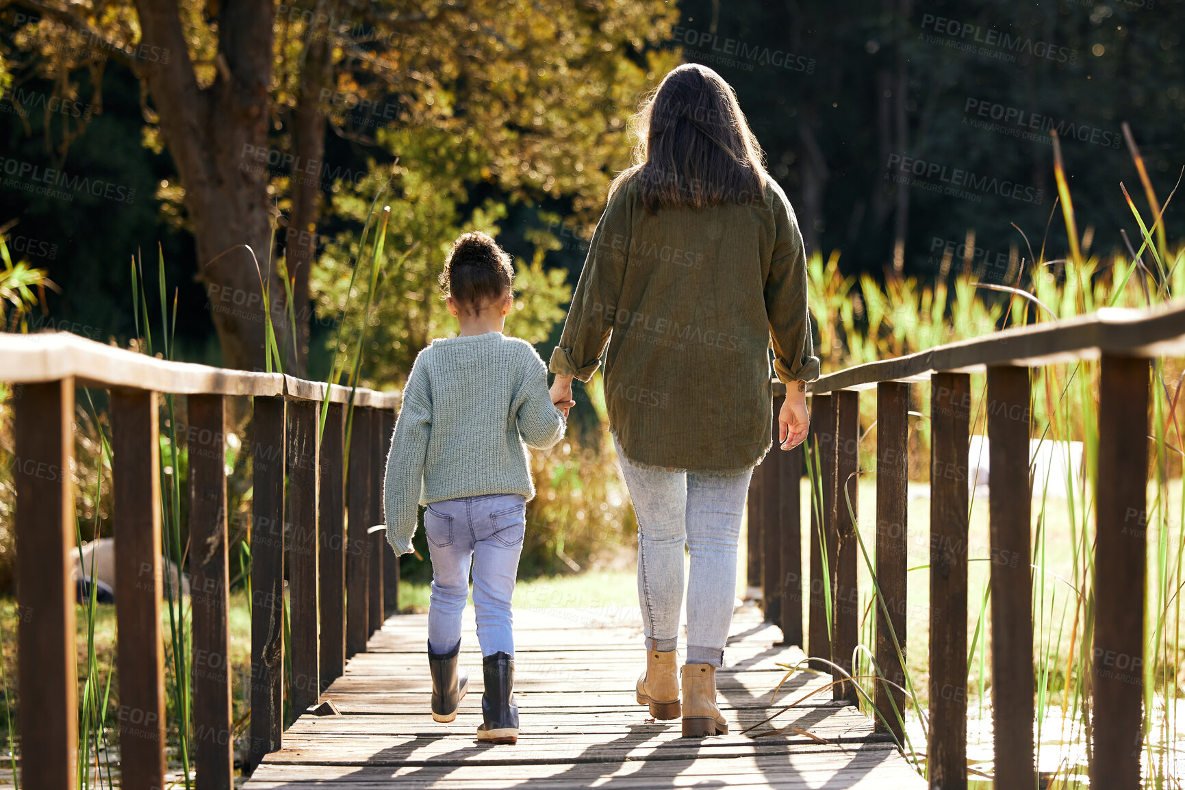 Buy stock photo Back, mother and girl holding hands, park and bonding with love, family and carefree with sunshine. Parent, mama and daughter outdoor, walking and break with care, natural and quality time outside