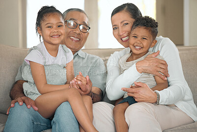 Buy stock photo Shot of a senior couple sitting on their sofa at home with their grandchildren