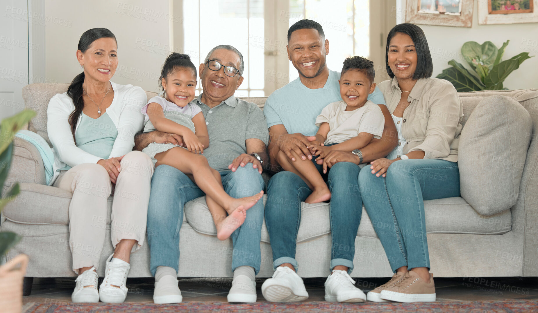 Buy stock photo Full length shot of a happy family sitting on the sofa at home and bonding