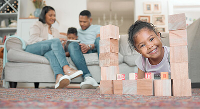 Buy stock photo Shot of an adorable little girl playing with building blocks in the living room at home