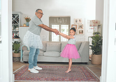 Buy stock photo Full length shot of an adorable little girl bonding with her grandfather while dancing with him in the living room