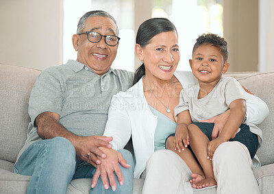 Buy stock photo Shot of a senior couple sitting on their sofa at home with their grandson