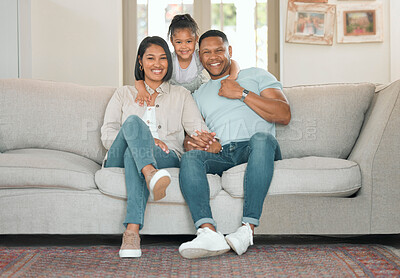 Buy stock photo Full length shot of a young couple sitting on their sofa at home with their daughter