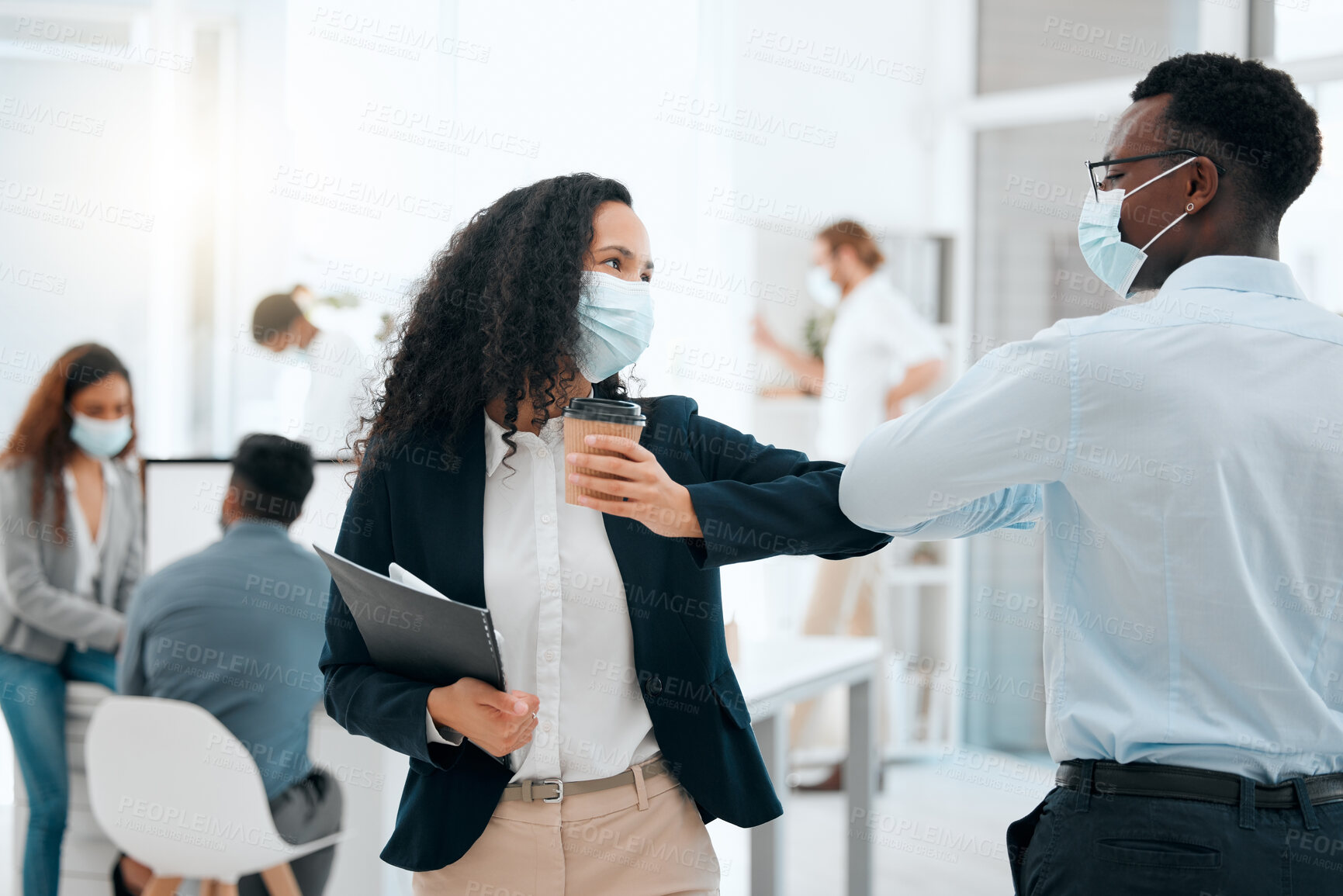 Buy stock photo Shot of two young businesspeople greeting each other with an elbow bump at work