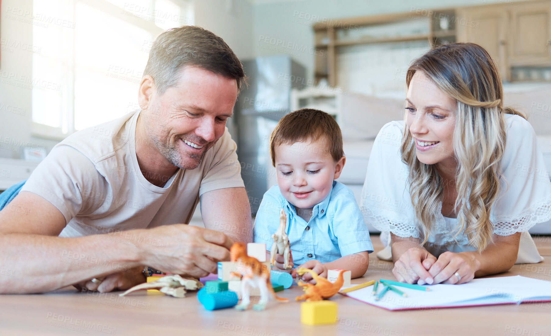 Buy stock photo Shot of a couple playing with their son at home