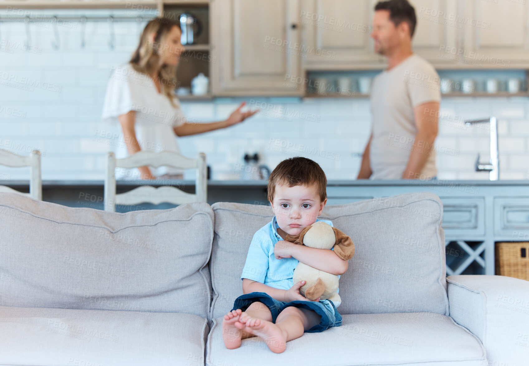 Buy stock photo Shot of a scared boy on the couch while his parents are arguing at home