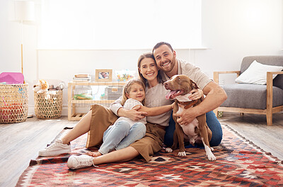 Buy stock photo Full length shot of a young family sitting with their dog on the living room floor at home