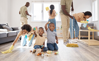 Buy stock photo Shot of two adorable little boys playing while their parents clean up around them at home