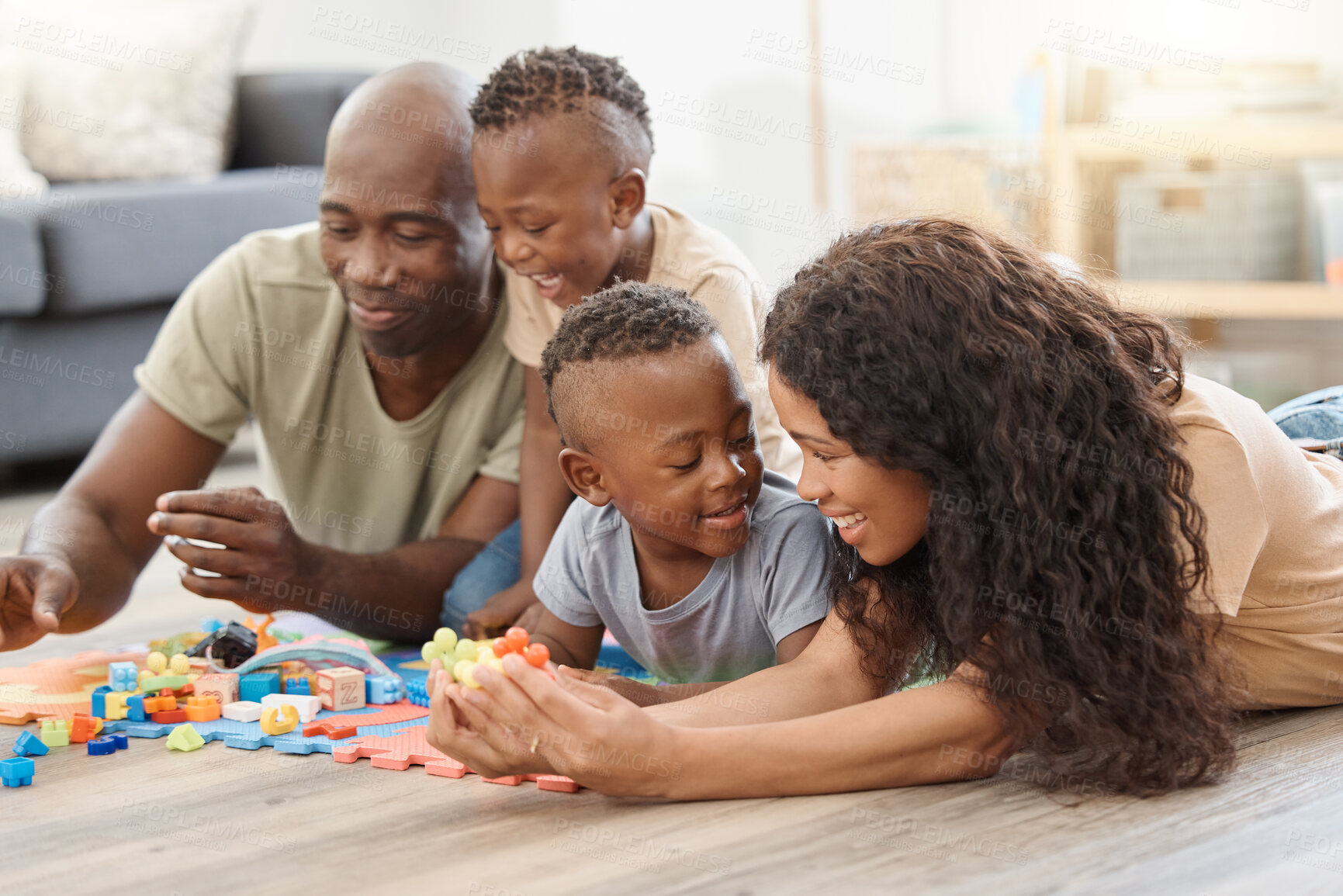 Buy stock photo Shot of a happy young family playing together on the floor at home
