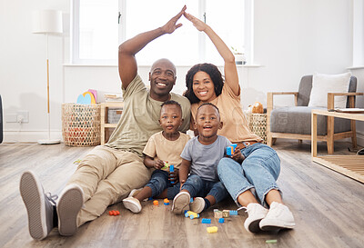 Buy stock photo Shot of a happy young family making a gesture above themselves during play time at home