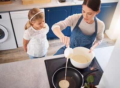 Buy stock photo Shot of a little girl watching her mother make pancakes