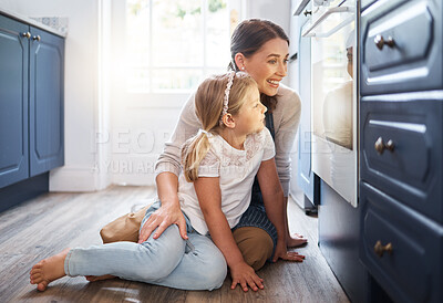 Buy stock photo Shot of a little girl and her mother watching something bake in the oven at home
