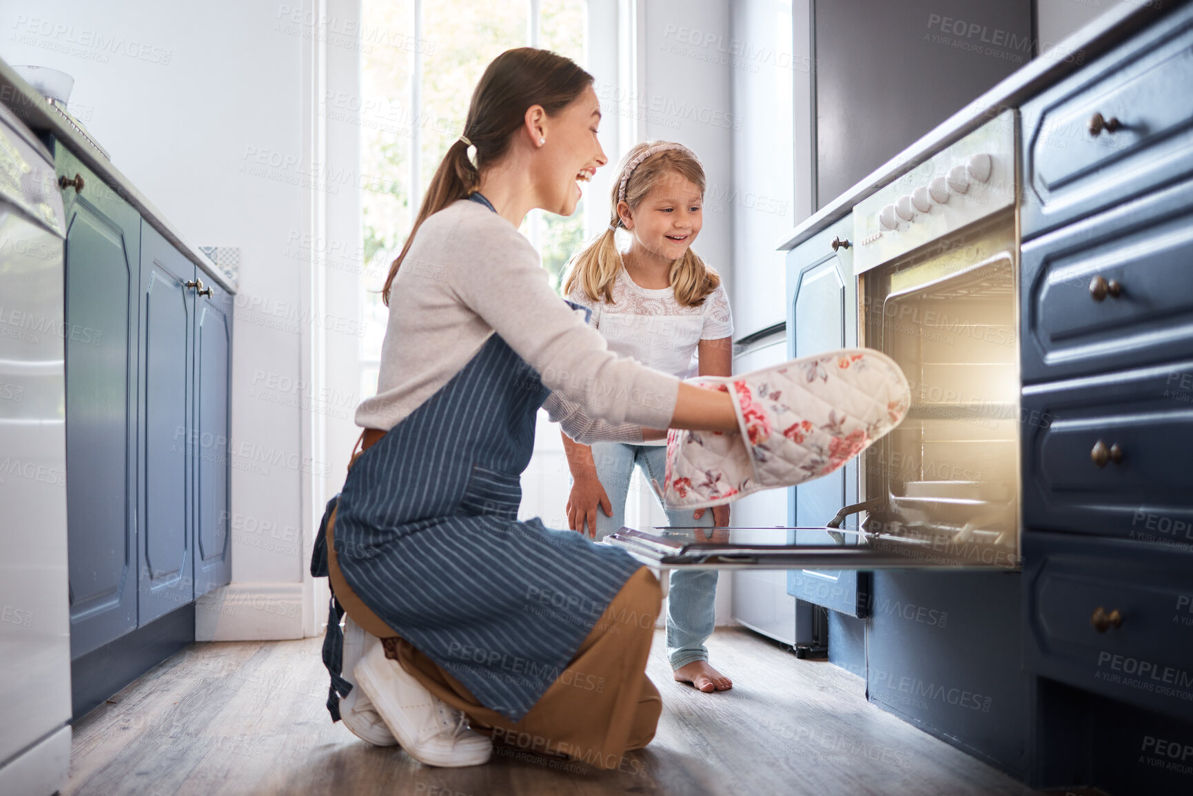 Buy stock photo Woman, girl and baking with oven or tray, excited and family in home for finished treat with mitts on for heat protection. Weekend beak, smile and bonding together, people and kitchen in apartment