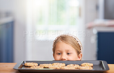 Buy stock photo Shot of an adorable little girl looking at cookies on a baking tray