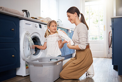 Buy stock photo Shot of a woman sitting with her daughter while doing laundry at home
