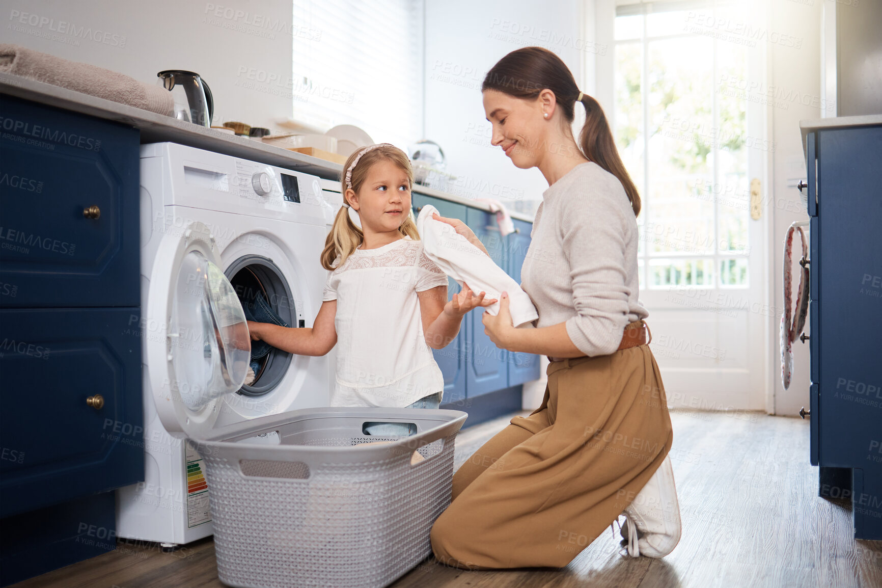 Buy stock photo Mother, girl and home with washing machine for laundry, child helping and woman with clothing or basket. Life skills, chores and together for bonding, maintenance routine and domestic or housework