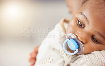 Buy stock photo Shot of an adorable baby girl sucking a dummy while being held by her mother at home
