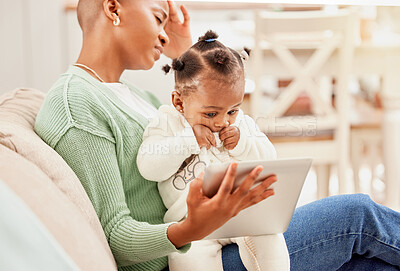 Buy stock photo Cropped shot of a young woman entertaining her daughter with a tablet while suffering with a headache on the sofa at home
