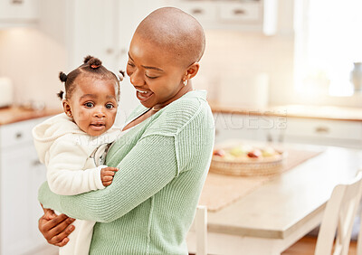 Buy stock photo Cropped shot of an attractive young woman carrying her daughter in the kitchen at home