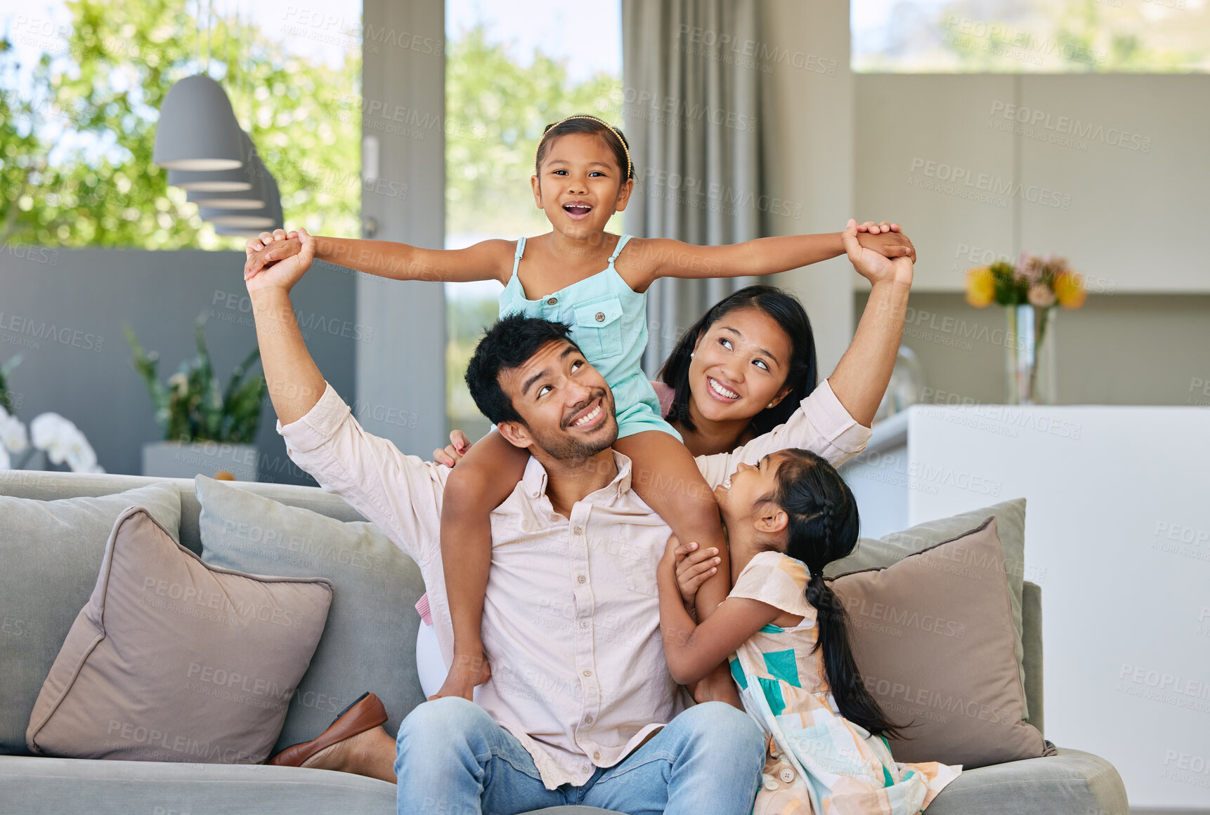Buy stock photo Portrait, parents and kids on sofa with airplane game, bonding and relax together in living room on weekend. Mom, dad and girl children on couch with fun, support and playing in home in Indonesia.