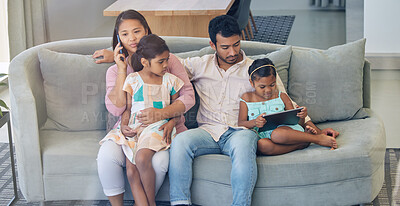 Buy stock photo Shot of a young family relaxing together while using a digital tablet