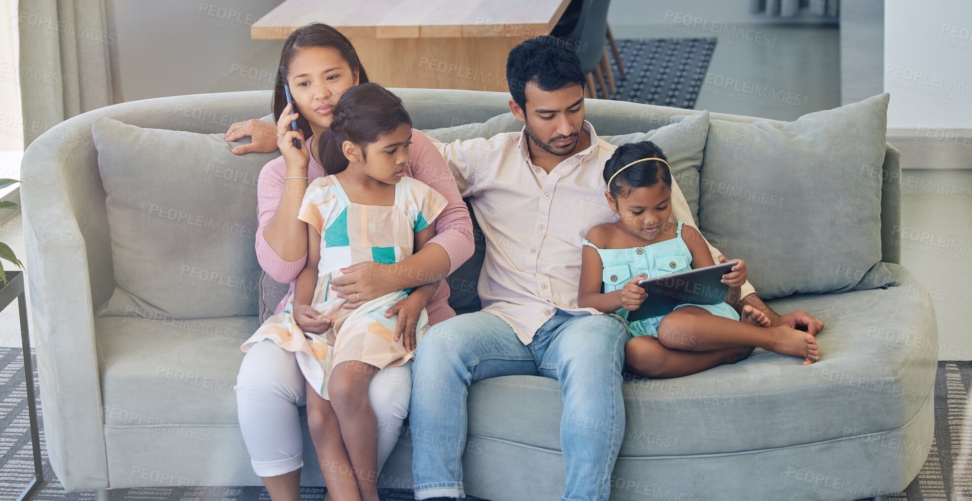 Buy stock photo Technology, parents and children on sofa with busy family, internet and relax together in home. Mom, dad and girl kids on couch watching tv with phone, tablet and online connectivity in living room.
