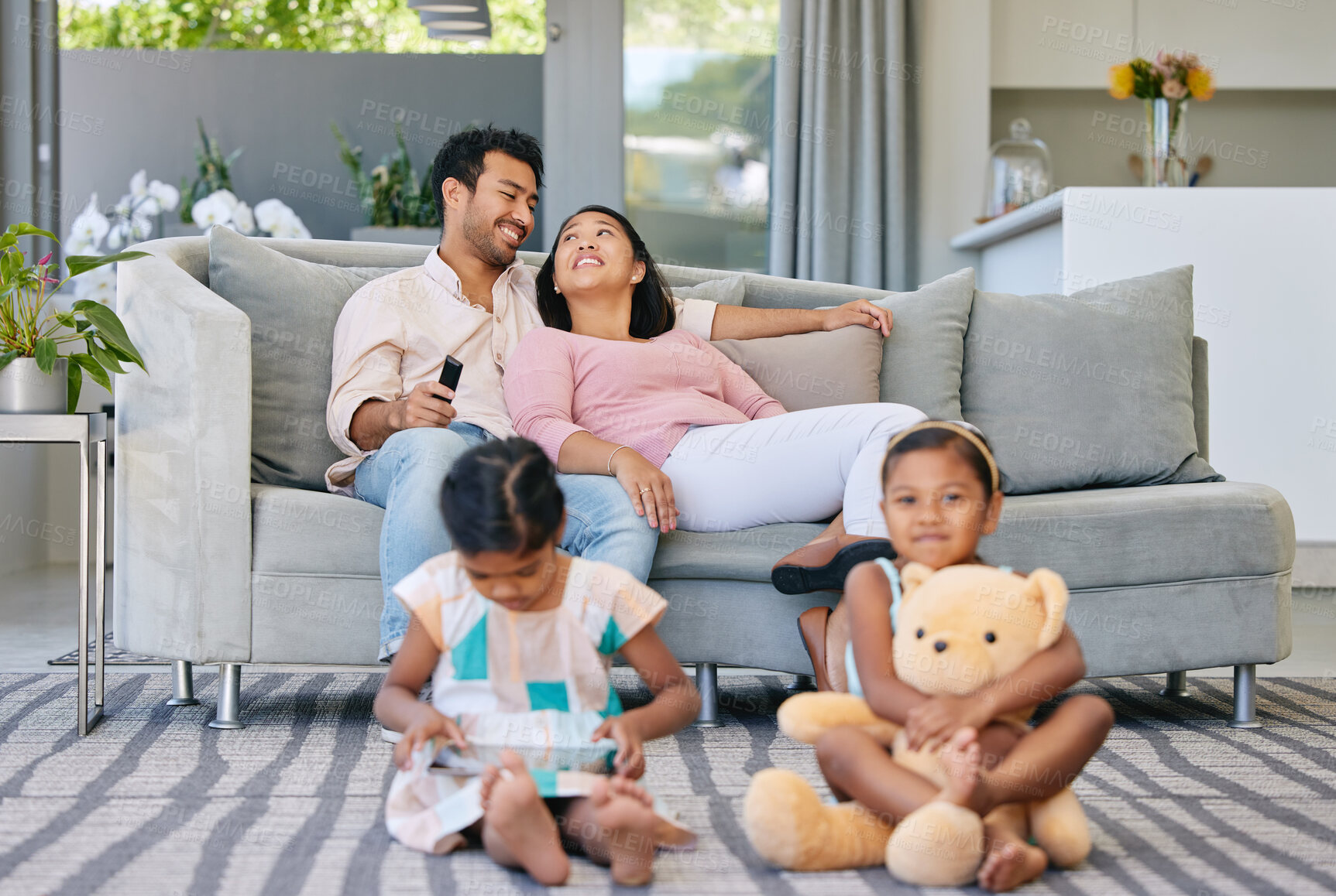 Buy stock photo Relax, parents and kids on sofa with busy family, watching tv and bonding together in smart home. Mom, dad and girl children on carpet with smile, tablet and online movie subscription in living room.