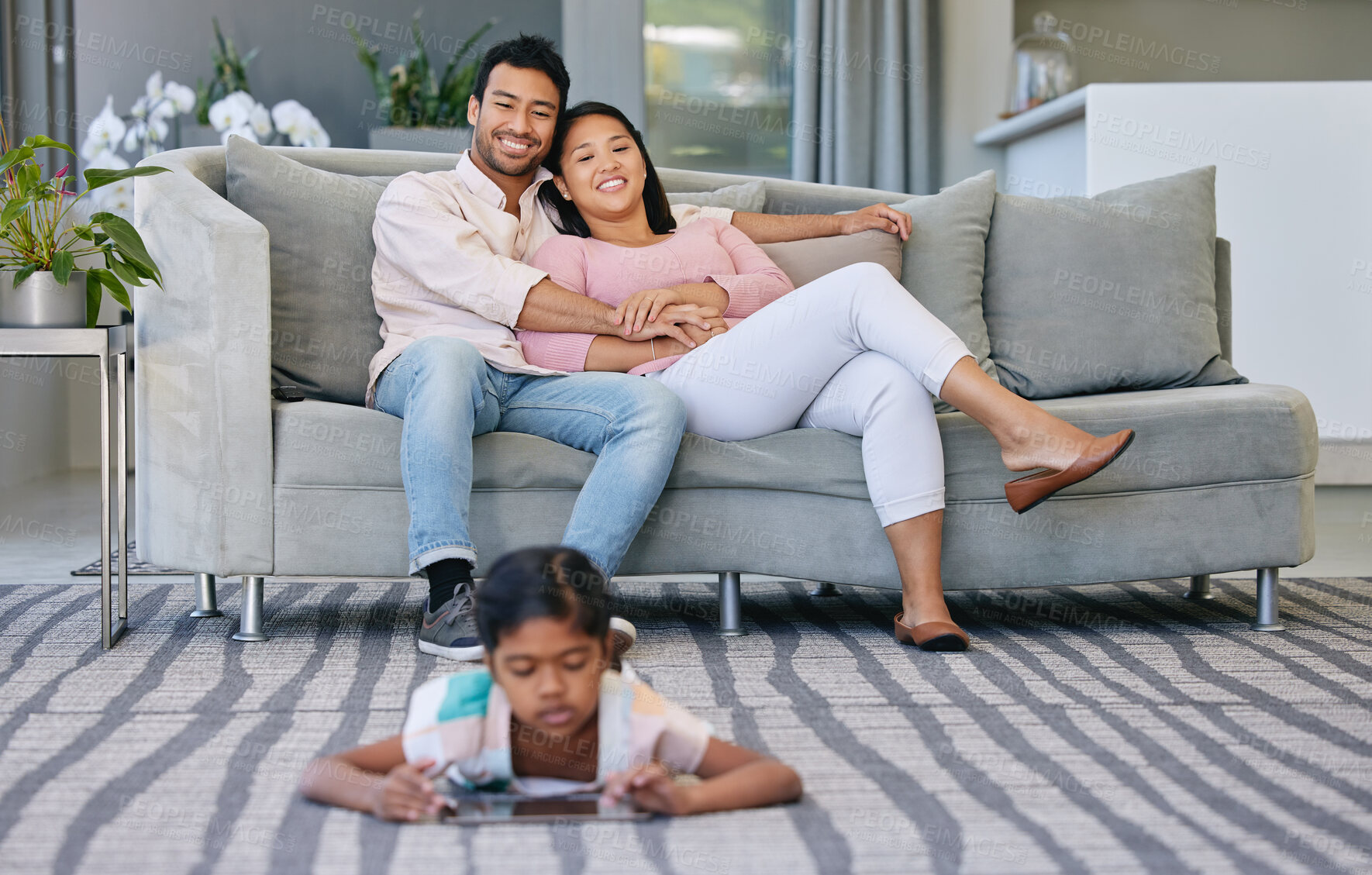 Buy stock photo Relax, parents and child with tablet in living room watching movie, film or show online at home. Happy, love and mother and father bonding on sofa with girl streaming with digital technology on floor