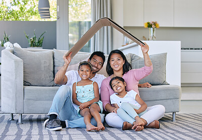 Buy stock photo Cardboard roof, portrait and family in a house for safety, security and investment. Happy, love and parents and children with a cover for family insurance, mortgage or property on the lounge floor