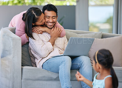 Buy stock photo Shot of a young wife kissing her husband while her daughter plays