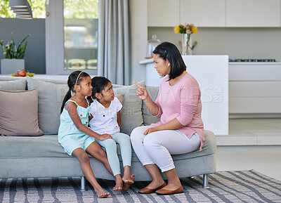 Buy stock photo Shot of a woman scolding her two daughters