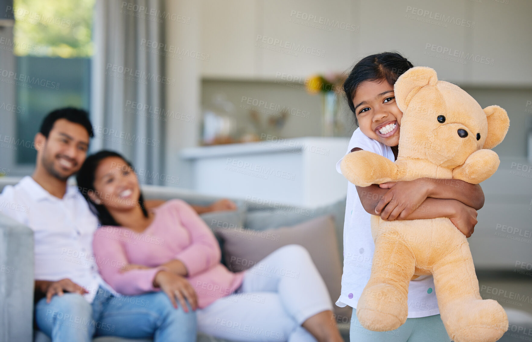 Buy stock photo Family, kid and teddy bear with hug in home, having fun and bonding with mother and father gift. Support, care and love of happy parents playing with girl holding toy with sofa in house living room