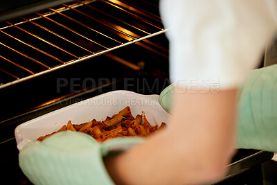 Buy stock photo Shot of an unrecognizable person removing food from an oven at home