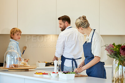 Buy stock photo Shot of a young family cooking together at home