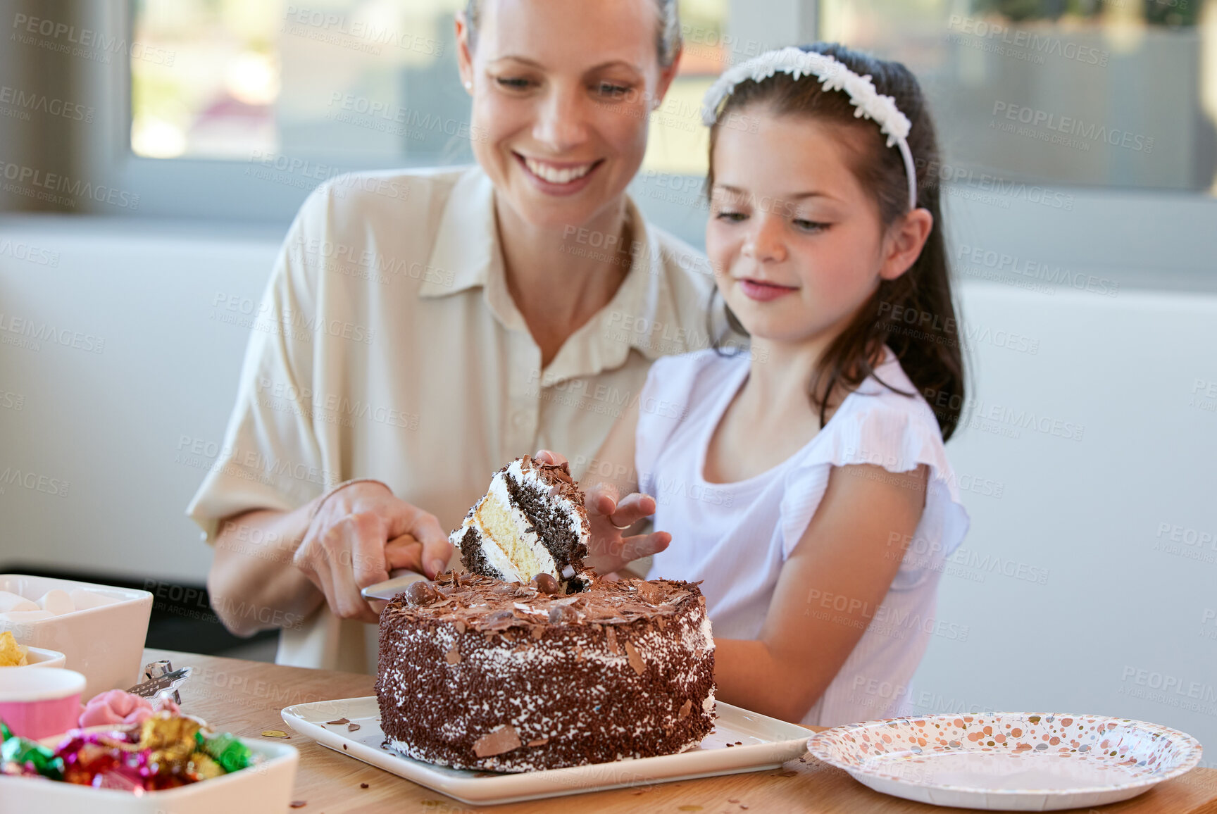 Buy stock photo Girl, party and cut birthday cake for eating, happy and surprise celebration in Germany home. Child, smile and love with homemade chocolate dessert on table, excited and support for family dinner