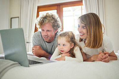 Buy stock photo Shot of a little girl bonding with her parents in bed at home
