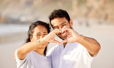 Buy stock photo Shot of a couple making a heart gesture on the beach