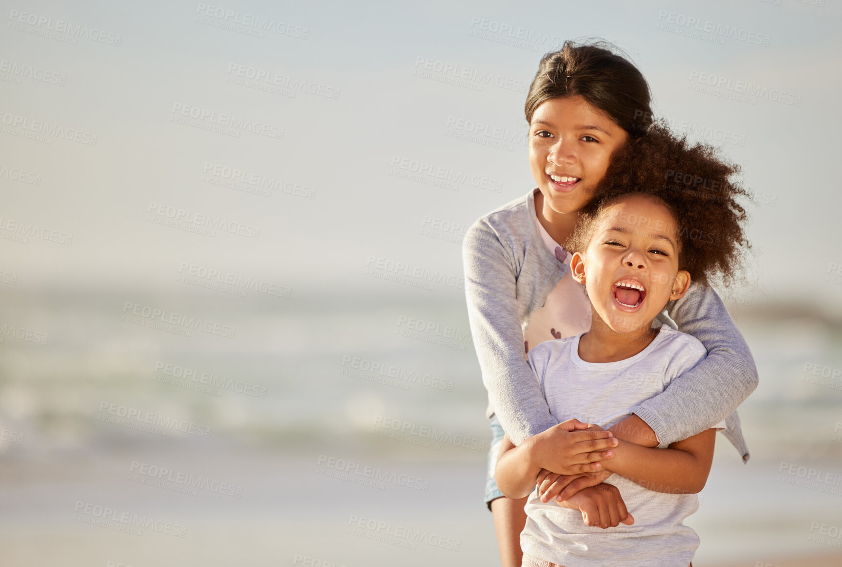 Buy stock photo Shot of  two sisters spending time together at the beach