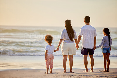 Buy stock photo Shot of a family watching the sunset at the beach
