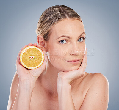 Buy stock photo Portrait, orange and skin care with woman in studio for facial treatment, natural glow or wellness on gray background. Clean, beauty and hand of model with fruit for vitamin c, organic or dermatology