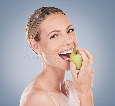 Buy stock photo Skincare, apple and portrait of happy woman in studio for natural glow, facial treatment or wellness on gray background. Eating, fruit and model with bite for nutrition, vitamin c or body detox