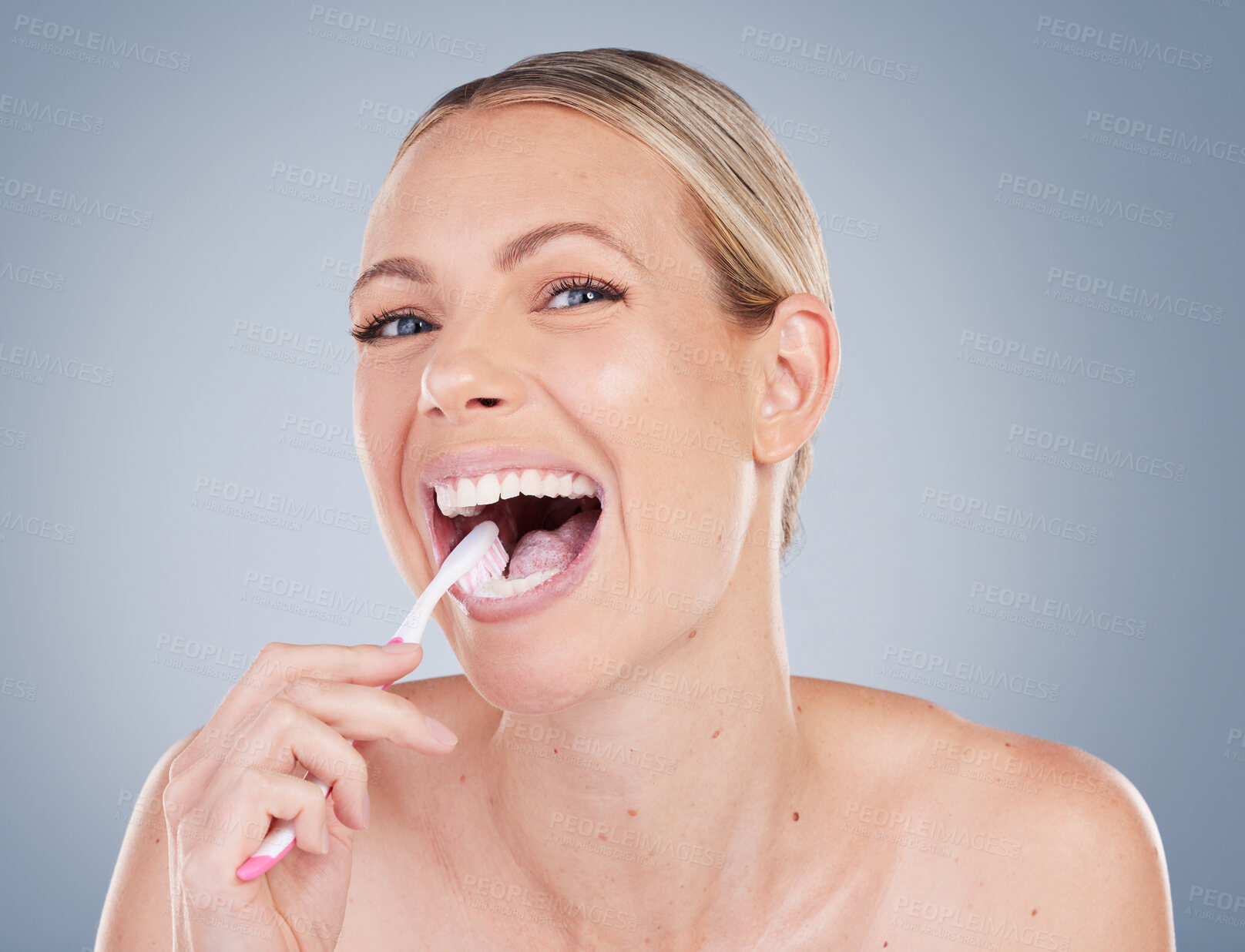 Buy stock photo Woman, portrait and brushing teeth in studio for oral care, dental hygiene and fresh breath. female model, toothbrush and wellness with smile, happiness and confidence or pride by gray background