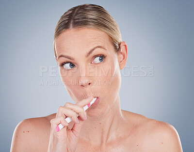 Buy stock photo Woman, thinking and brushing teeth in studio ideas for self care and dental wellness on background. Healthy, cleaning model with toothbrush, toothpaste and plan for dentistry, healthcare or routine