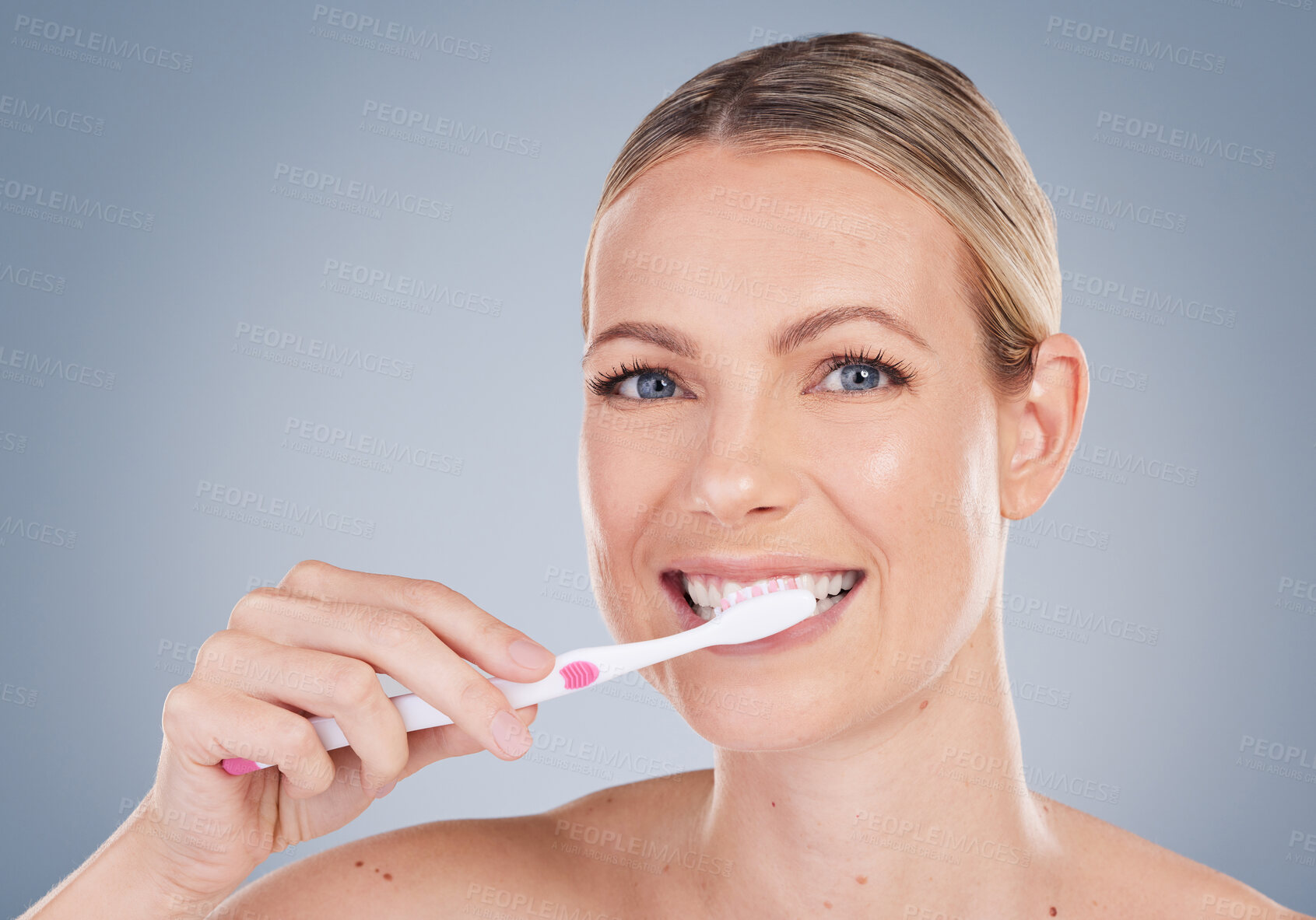 Buy stock photo Woman, portrait and brushing teeth in studio for dental care, oral hygiene and fresh breath. Female model, toothbrush and wellness with smile, happiness and confidence or pride by gray background