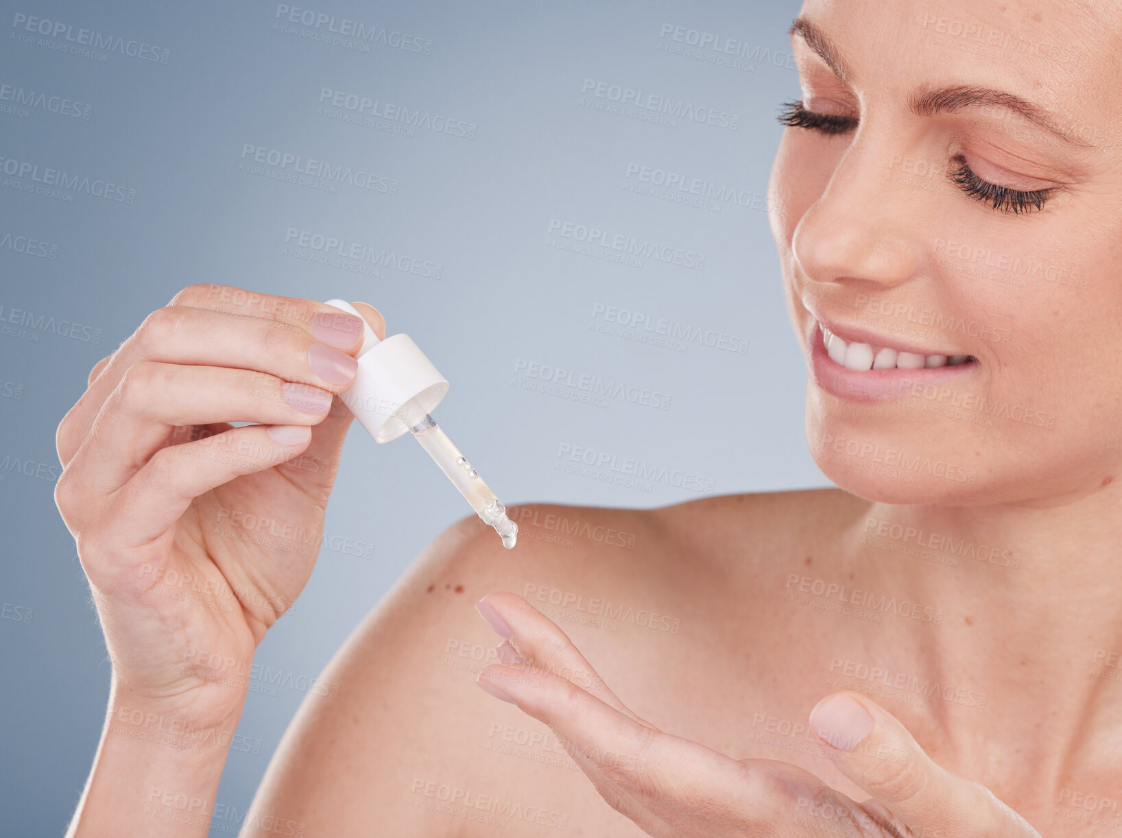 Buy stock photo Skincare, happy woman and serum dropper for beauty, dermatology and glow in studio isolated on gray background. Cosmetics, pipette and model apply essential oil, hyaluronic acid and facial collagen