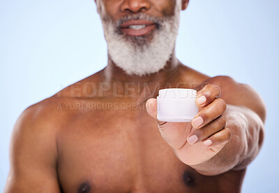 Buy stock photo Cropped shot of a mature man holding face moisturiser in his hand against a blue background