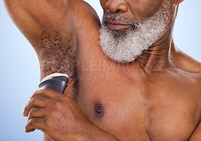 Buy stock photo Cropped shot of a mature man applying deodorant to his armpit against a blue background